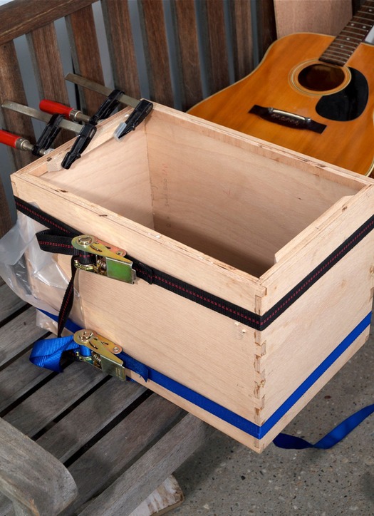 De box van de cajon zit in elkaar, lijmverbinding met zwaluwstaarten ligt te drogen. De drager van het blad zit er op en de snaarhouder zit boven nog in de lijmklemmen De gitaar is niet blij...